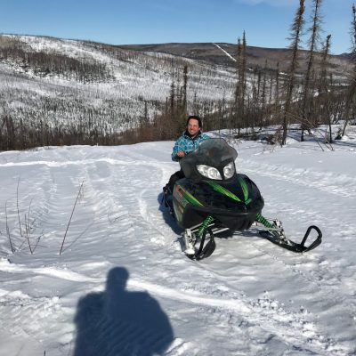 a man riding a snowboard down a snow covered slope