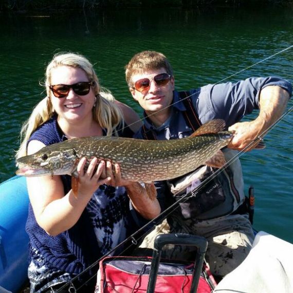 a person holding a fish on a boat in a body of water