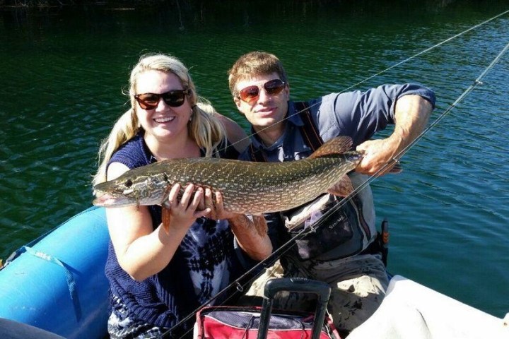 a person holding a fish on a boat in the water