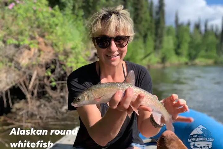 a woman holding a fish