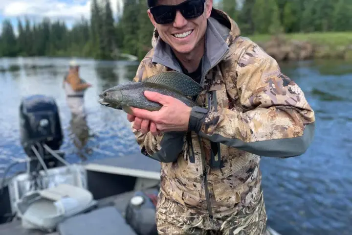 a man holding a fish in the water
