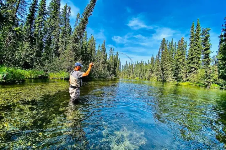 a man standing in front of a pond