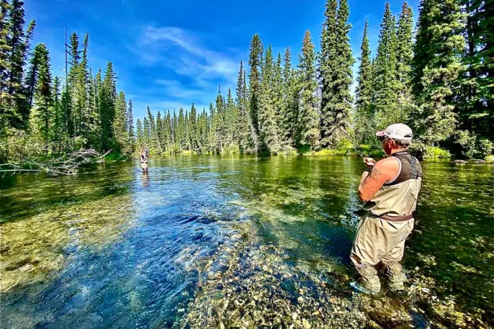 a man standing next to a river