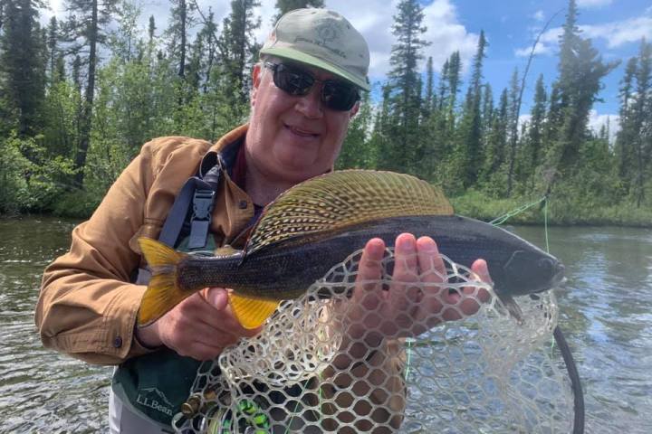 a man holding a fish in the water