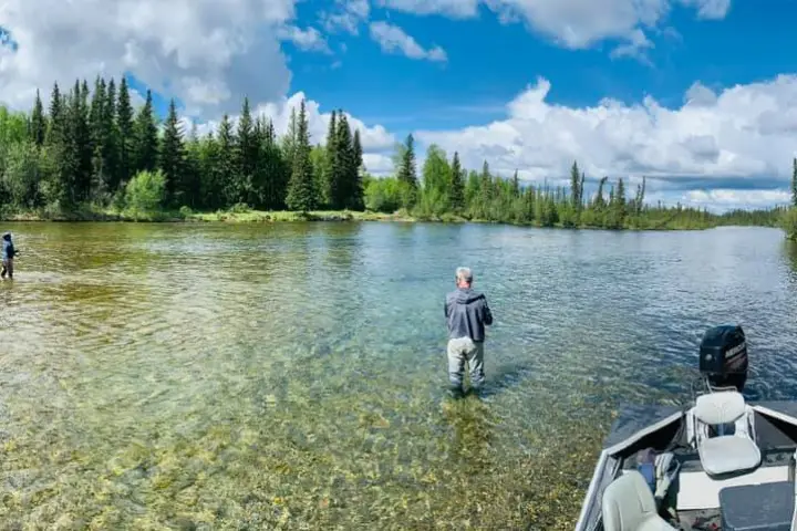 a man standing next to a body of water