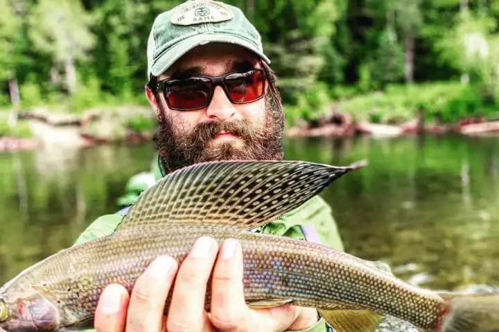 a man holding a fish in the water