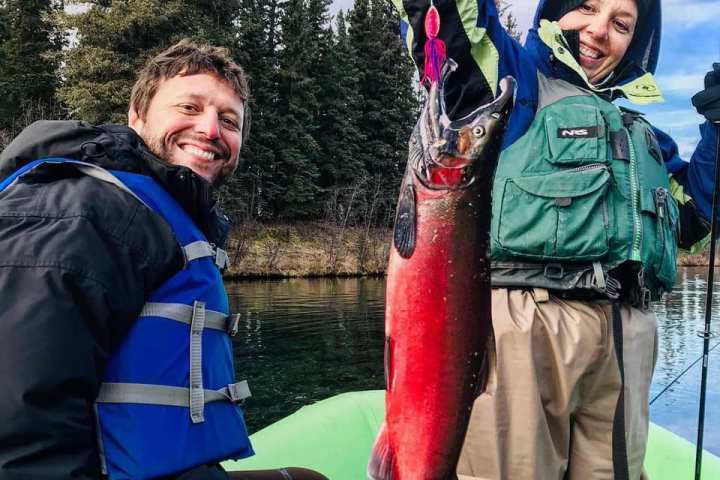 a person holding a fish posing for the camera
