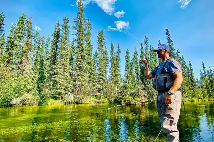 a man standing next to a lake
