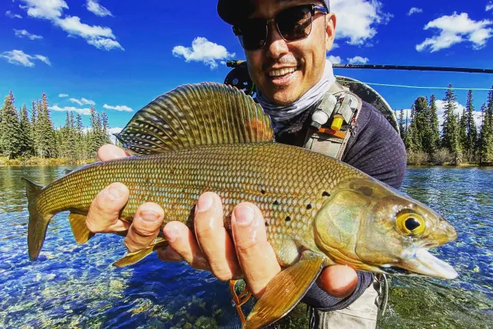 a man holding a fish in the water