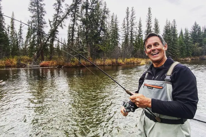 a man standing next to a lake
