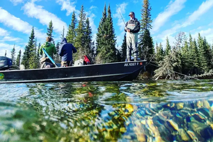 a group of people riding on the back of a boat in the water