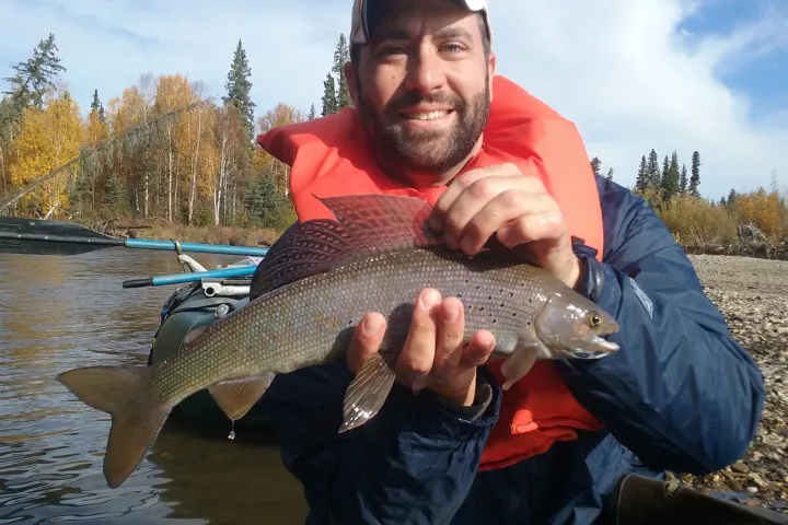 a man holding a fish in the water