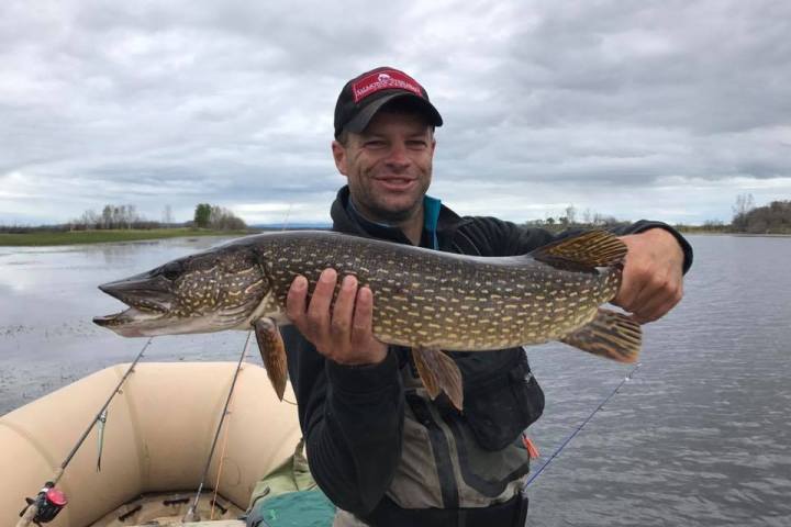 a man holding a fish in the water