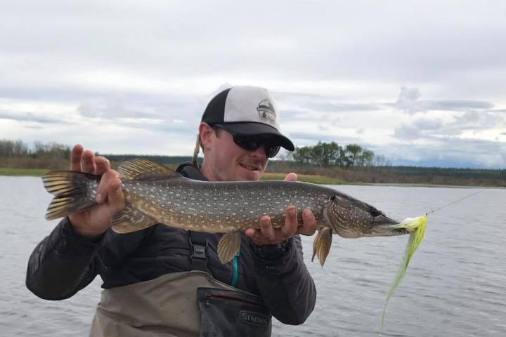 a man holding a fish in the water