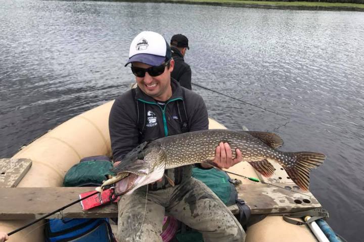 a person holding a fish on a boat in the water