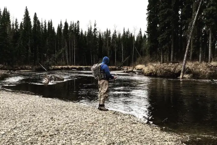 a man standing next to a lake