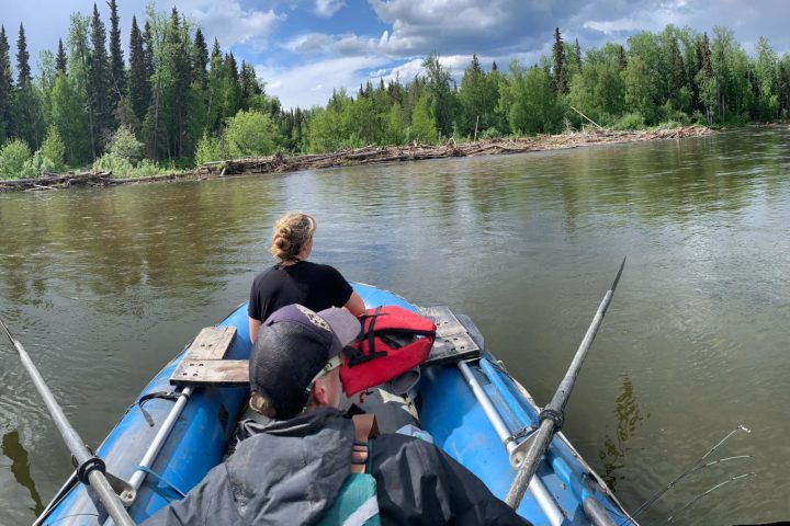 a man riding on the back of a boat in a body of water