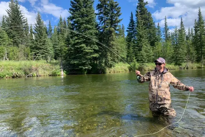 a man standing next to a lake
