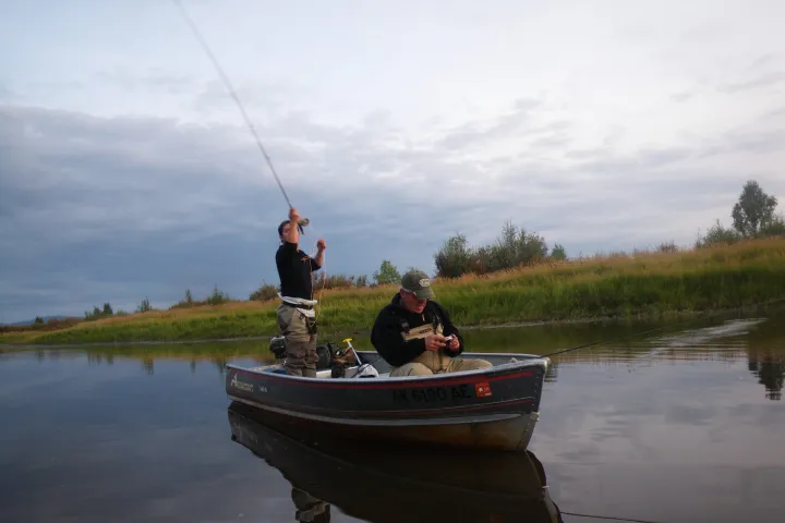 a man riding on the back of a boat in a body of water