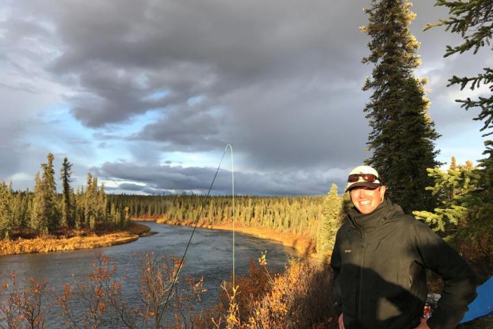 a man standing next to a tree