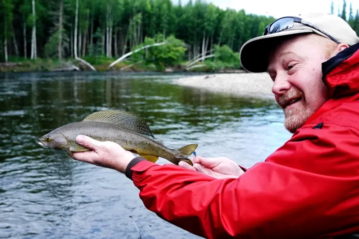 a man holding a fish in the water