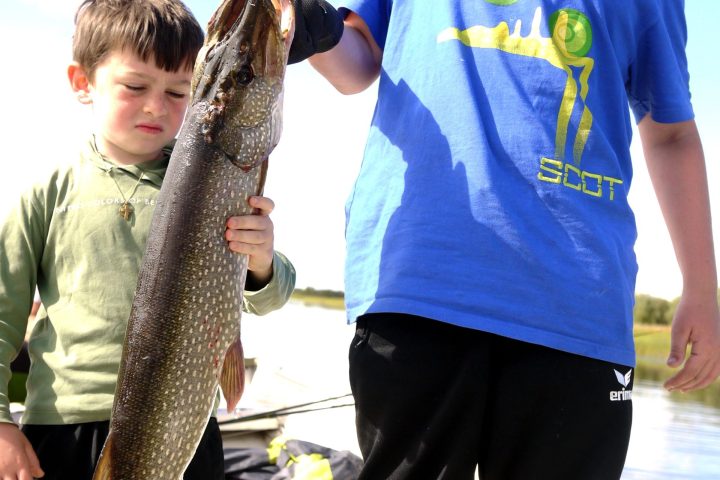 a young boy holding a fish