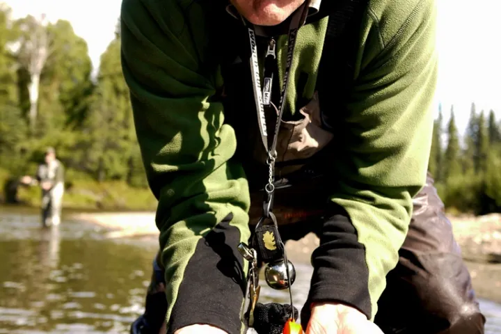a man holding a fish in the water