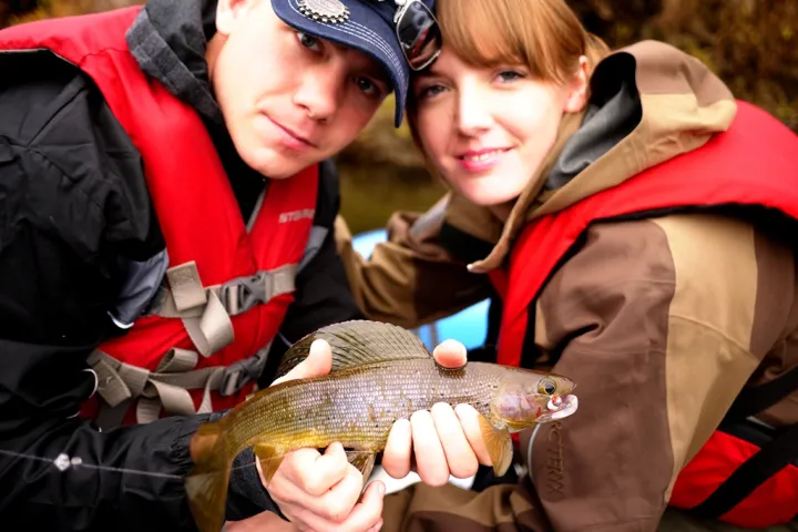 a close up of a person holding a fish