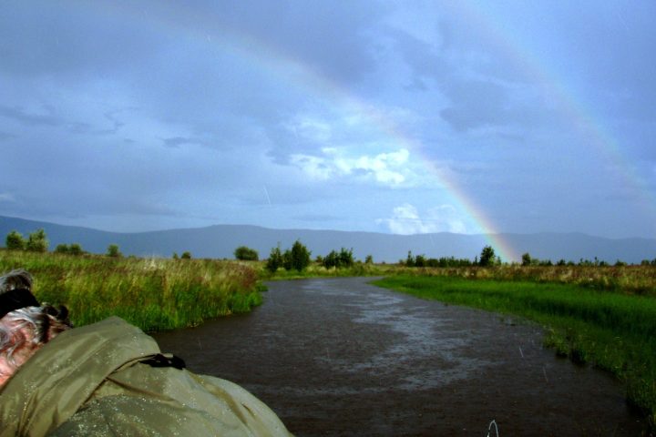 a person sitting on the side of a river