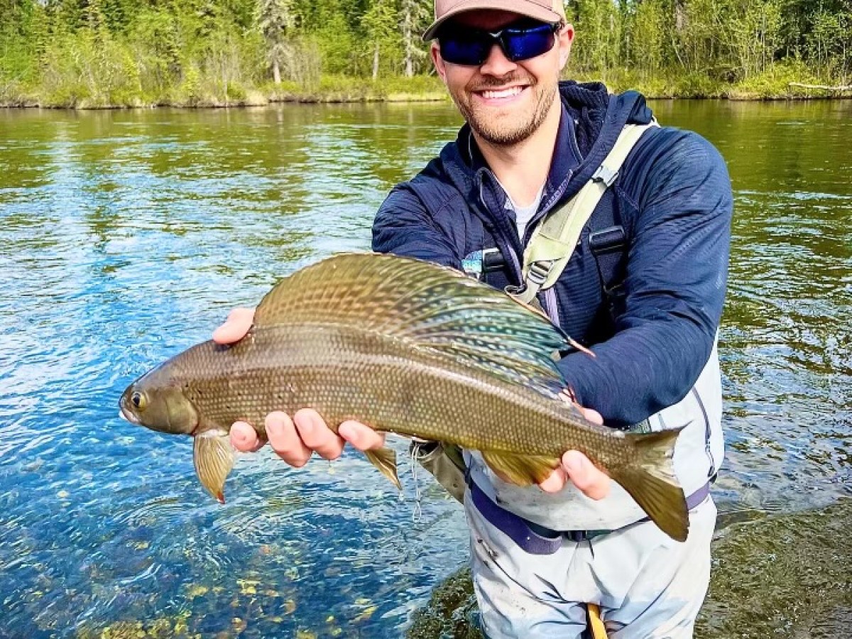 a man holding a fish in the water