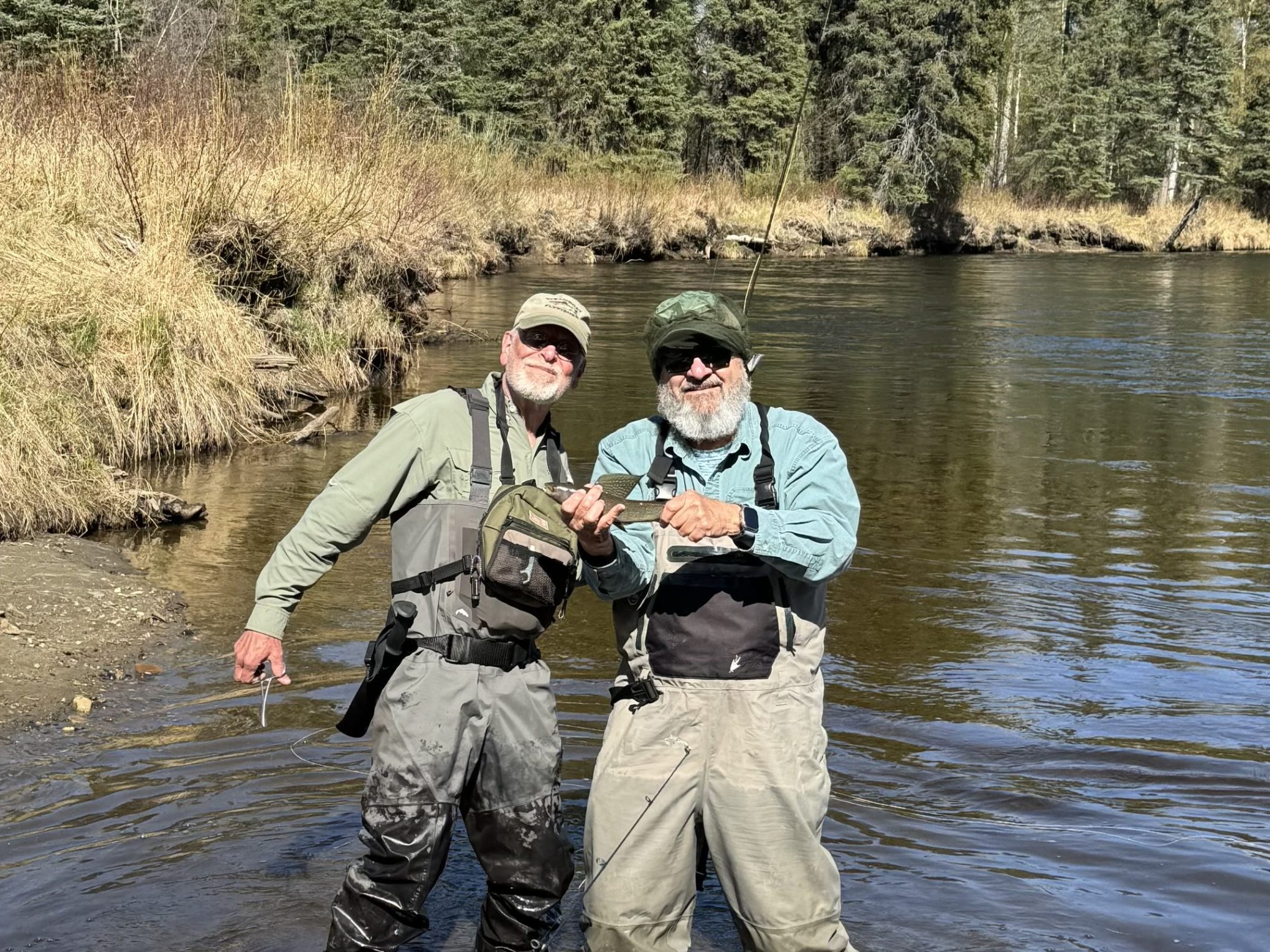 a man standing next to a lake