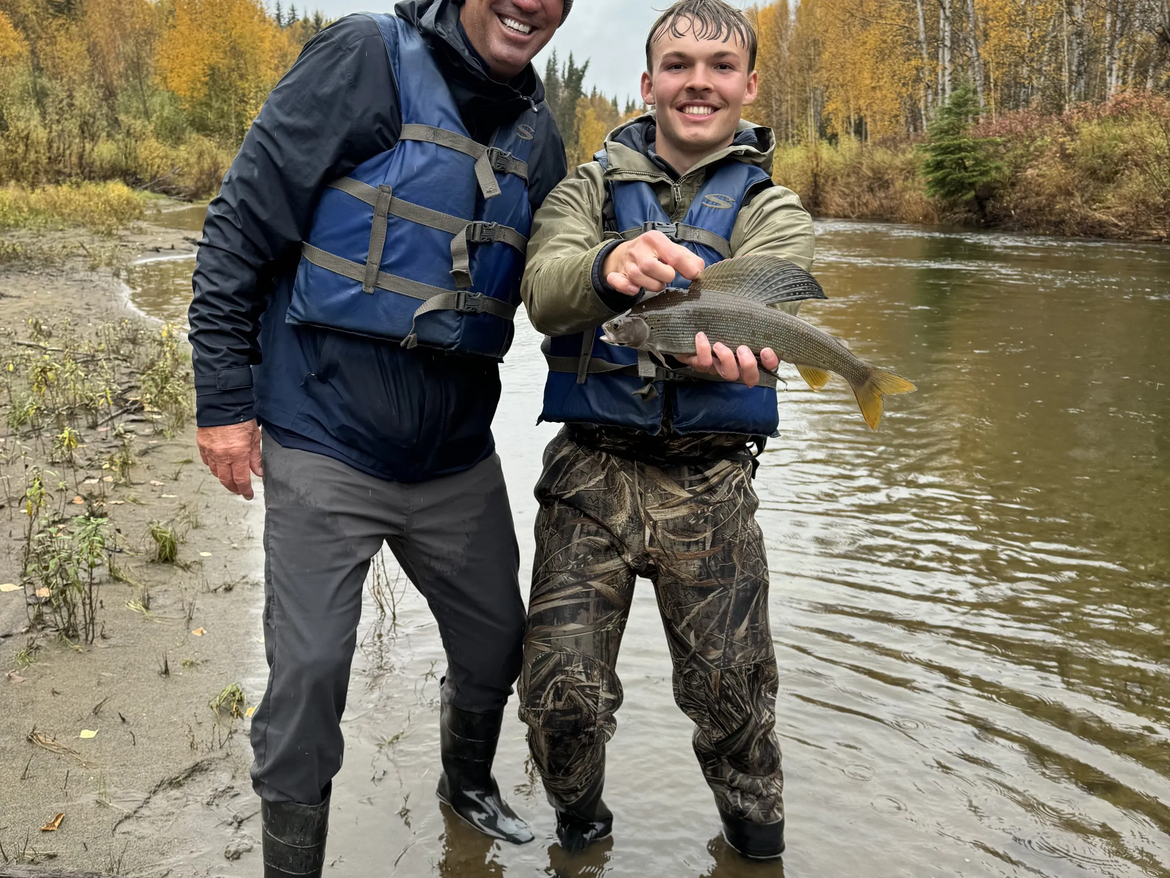 a man standing next to a river